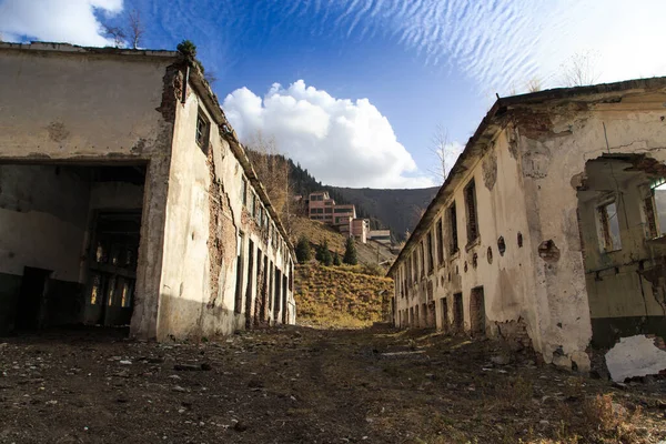 Old abandoned building. Ruins of a former factory. Dirty, dirty walls. View of mountains and trees. Kyrgyzstan, Factory Ak-Tuz