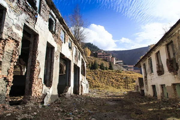 Old abandoned building. Ruins of a former factory. Dirty, dirty walls. View of mountains and trees. Kyrgyzstan, Factory Ak-Tuz