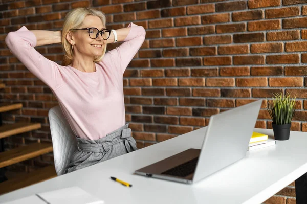 Spokojená podnikatelka středního věku relaxující na pracovišti v kanceláři — Stock fotografie