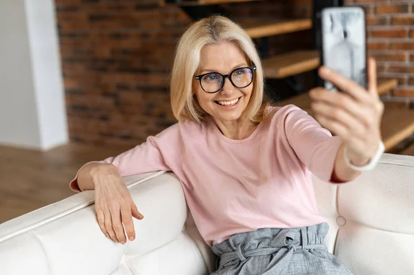 Usmívající se zralá žena blondýny mluvit online na mobilním telefonu — Stock fotografie