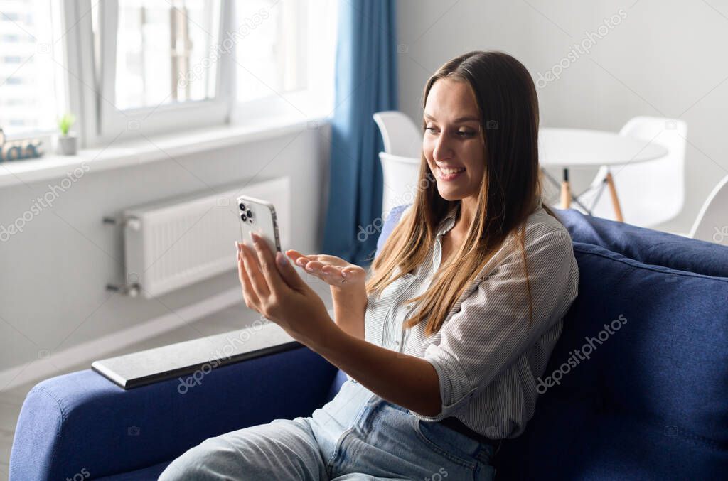 Cheerful wman using trendy smartphone for video connection