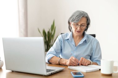 Ofisteki yaşlı, gri saçlı bayan çalışan.