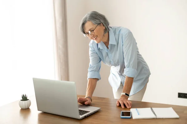 Senior gråhårig kvinnlig anställd på kontoret — Stockfoto