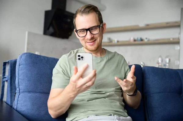 Sonriente tipo con ropa casual habla por video conectar en el teléfono inteligente — Foto de Stock