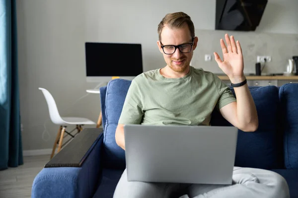 Jonge freelancer man draagt bril met laptop computer voor videoverbinding — Stockfoto