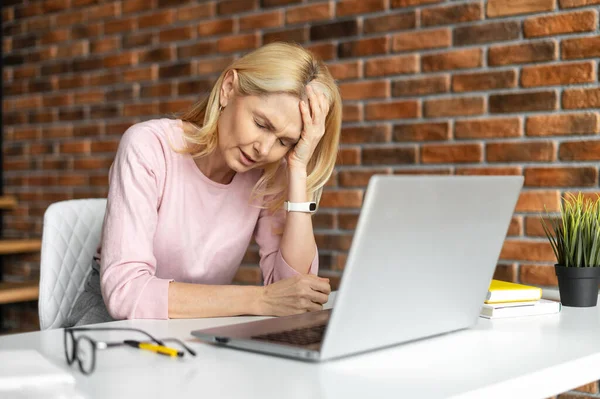 Unavená frustrovaná žena středního věku pomocí notebooku pro práci — Stock fotografie