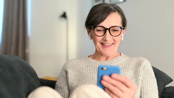 Mulher sênior usando smartphone em casa para videochamada — Vídeo de Stock