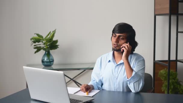 スマートフォンで話すインテリジェントなインドの男性オフィスの従業員 — ストック動画