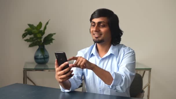 Sonriente y amigable hombre indio haciendo videollamada en el teléfono inteligente — Vídeos de Stock