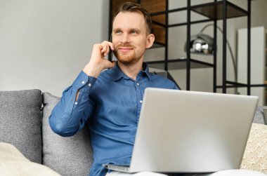 Kanepede oturan akıllı telefondan konuşan dost canlısı bir girişimci.