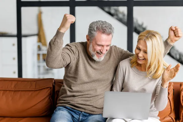 Idős pár használja laptop nézni sport mérkőzés vagy online lottó — Stock Fotó