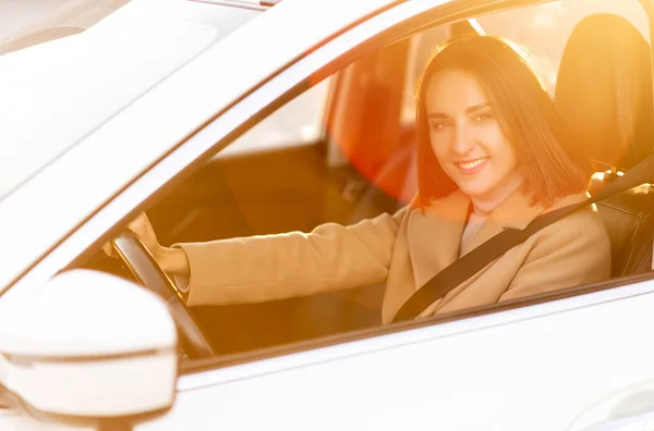 Молодая женщина в пальто водит машину — стоковое фото