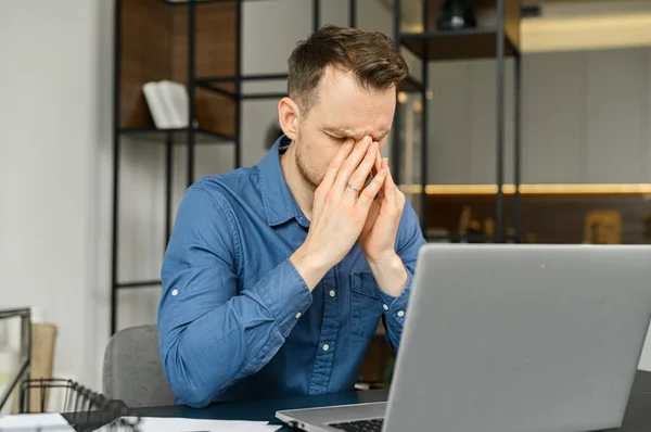 Fatigued guy using laptop for working — Stock Photo, Image