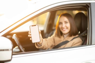 Kadın sürücünün elindeki boş telefon ekranına seçici odaklanma