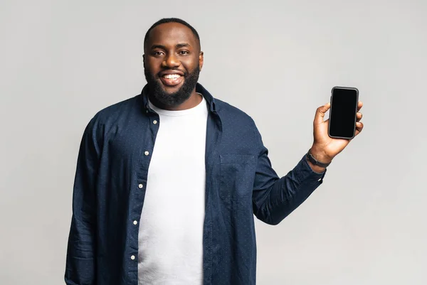 Porträtt av leende afroamerikansk kille som håller i smartphone — Stockfoto