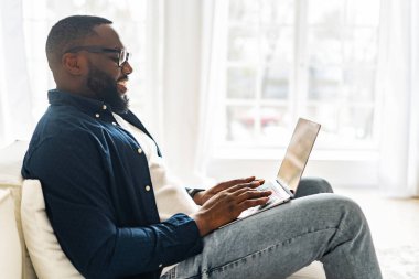 Laptop kullanan genç Afro-Amerikan serbest çalışana yan bakış