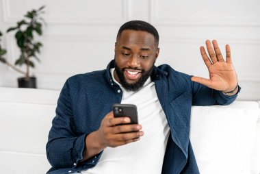 Video bağlantısı için akıllı telefon kullanan heyecanlı Afro-Amerikalı adam