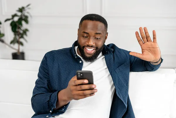 Spännande positiv afroamerikansk kille som använder smartphone för videoanslutning — Stockfoto