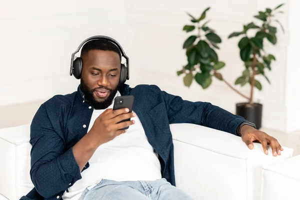Atractivo millennial joven barbudo africano hombre con auriculares —  Fotos de Stock