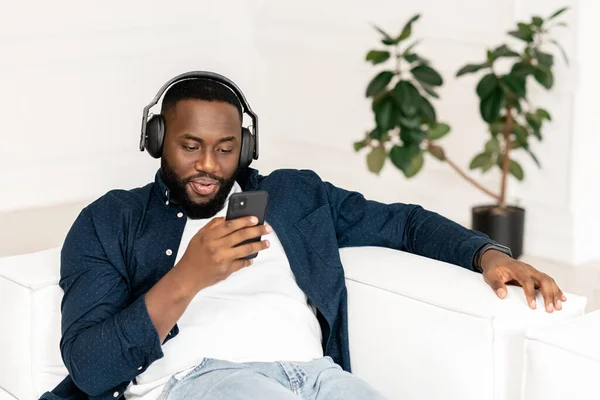 Atractivo millennial joven barbudo africano hombre con auriculares — Foto de Stock