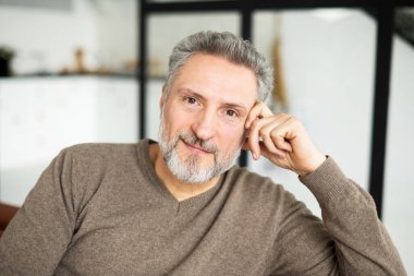 Çekici, olgun bir adamın, kameraya bakan portresi.