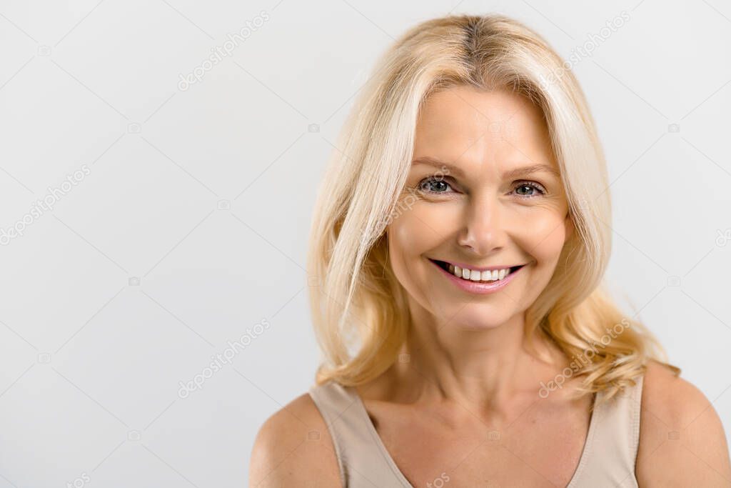 Close-up portrait of fresh and gorgeous middle-aged woman with pure and healthy skin