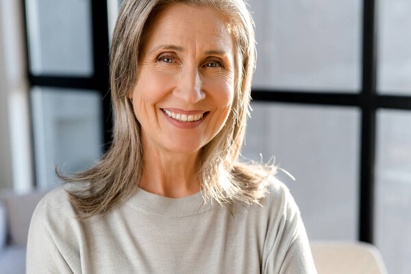 Крупный план портрета веселой старшей предпринимательницы в ярком современном офисе