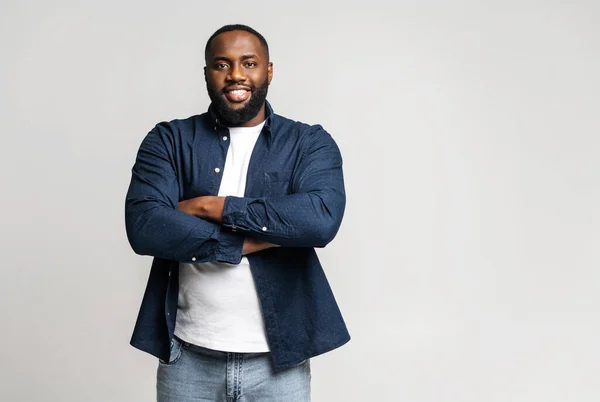 Trots en blij Afro-Amerikaanse man in casual kleding staat met gekruiste armen — Stockfoto