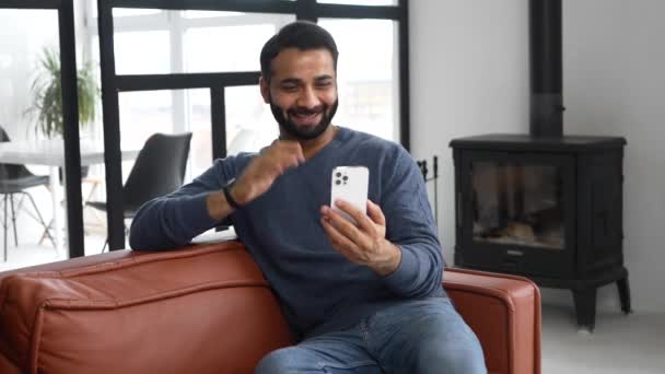 Snygg indisk kille som använder en smartphone för videosamtal — Stockvideo
