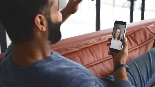 Indiano homem segurando smartphone e falando online com uma jovem mulher — Vídeo de Stock