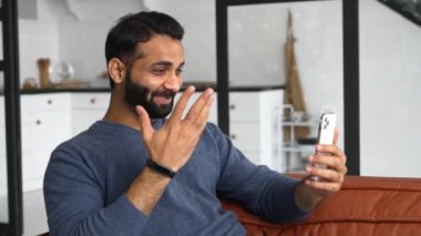 Sıradan giyinen Hintli bir adam sanal iletişim için akıllı telefon uygulaması kullanıyor