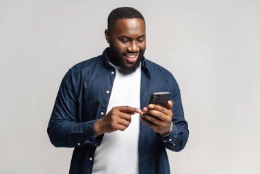 Gride izole edilmiş akıllı telefon kullanan neşeli Afro-Amerikalı adam.
