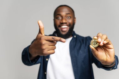 Erkeklerin elindeki bitcoin 'e seçici odaklanma, adam onu işaret eder.