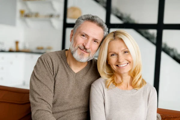 Lugnt och bekymmerslöst medelålders par i kärlek tittar på kameran och ler — Stockfoto