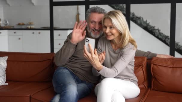 Casal de meia-idade está fazendo chamada de vídeo por um smartphone — Vídeo de Stock