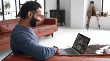 Video iletişimi için bilgisayar uygulaması kullanan genç Hintli adam.