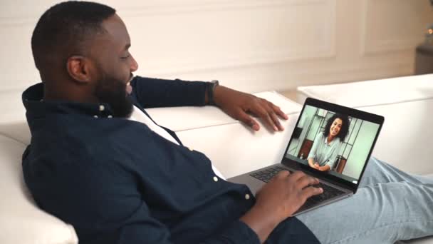 Hombre afroamericano tiene reunión virtual con una amiga, novia o colega — Vídeo de stock