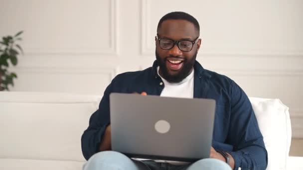 Podekscytowany szczęśliwy 30s Afryki facet korzystających wirtualne spotkanie — Wideo stockowe