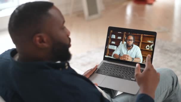Afroamerykanin biorący udział w kursach językowych online, nauczyciel online na ekranie laptopa — Wideo stockowe