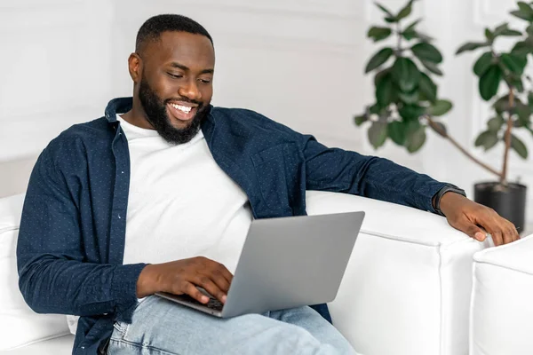 stock image Serene young 30s African-American guy using laptop in relaxed home atmosphere