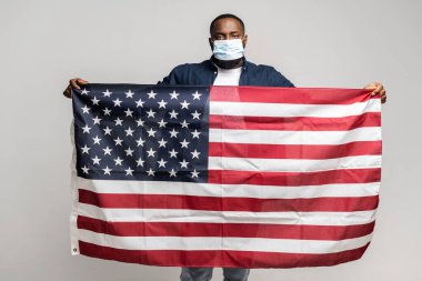 Amerikan bayrağı taşıyan ciddi bir Afro-Amerikalı.