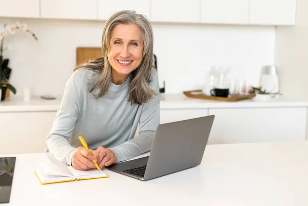 Весела жінка середнього віку працює віддалено, бізнес-леді слухає онлайн-вебінар — стокове фото