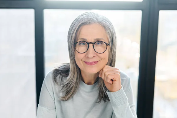 Positiva mujer de negocios senior con gafas elegantes mira a la cámara y sonríe — Foto de Stock