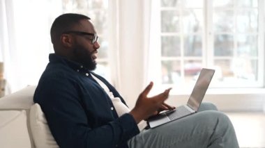 Keyifli genç sakallı Afro-Amerikan adam, el sallayarak webcam 'e giriyor.