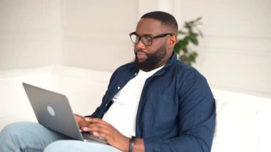 Laptop kullanan genç Afro-Amerikan serbest çalışana yan bakış