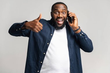 Akıllı telefondan konuşan yakışıklı Afro-Amerikalı bir adamın portresi.