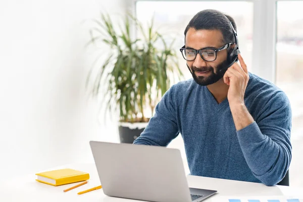Hintli ofis çalışanı gözlüklü ve kulaklıklı bilgisayar ekranına bakıyor ve internette konuşuyor. — Stok fotoğraf