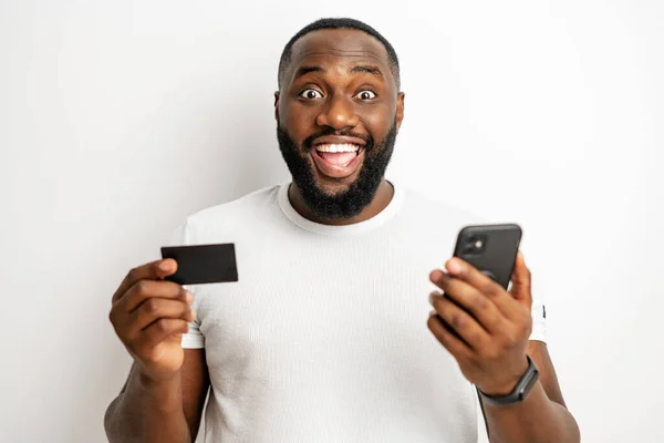 Szczęśliwy czarny człowiek w casual t-shirt otrzymują zwrot pieniędzy z zakupów online — Zdjęcie stockowe
