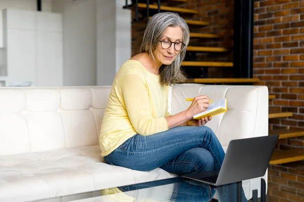 Charmante femme mûre d'âge moyen regardant des webinaires en ligne sur l'ordinateur portable — Photo