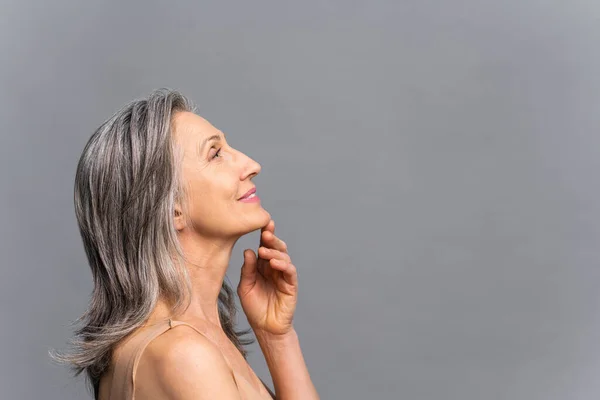 Bright mature lady standing in profile looks up — Stock Photo, Image